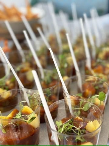 Vasitos individuales con aperitivos glaseados y brochetas dispuestos para el arranque del evento