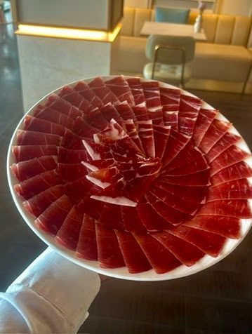 Camarero sirviendo un plato de jamón ibérico en sala