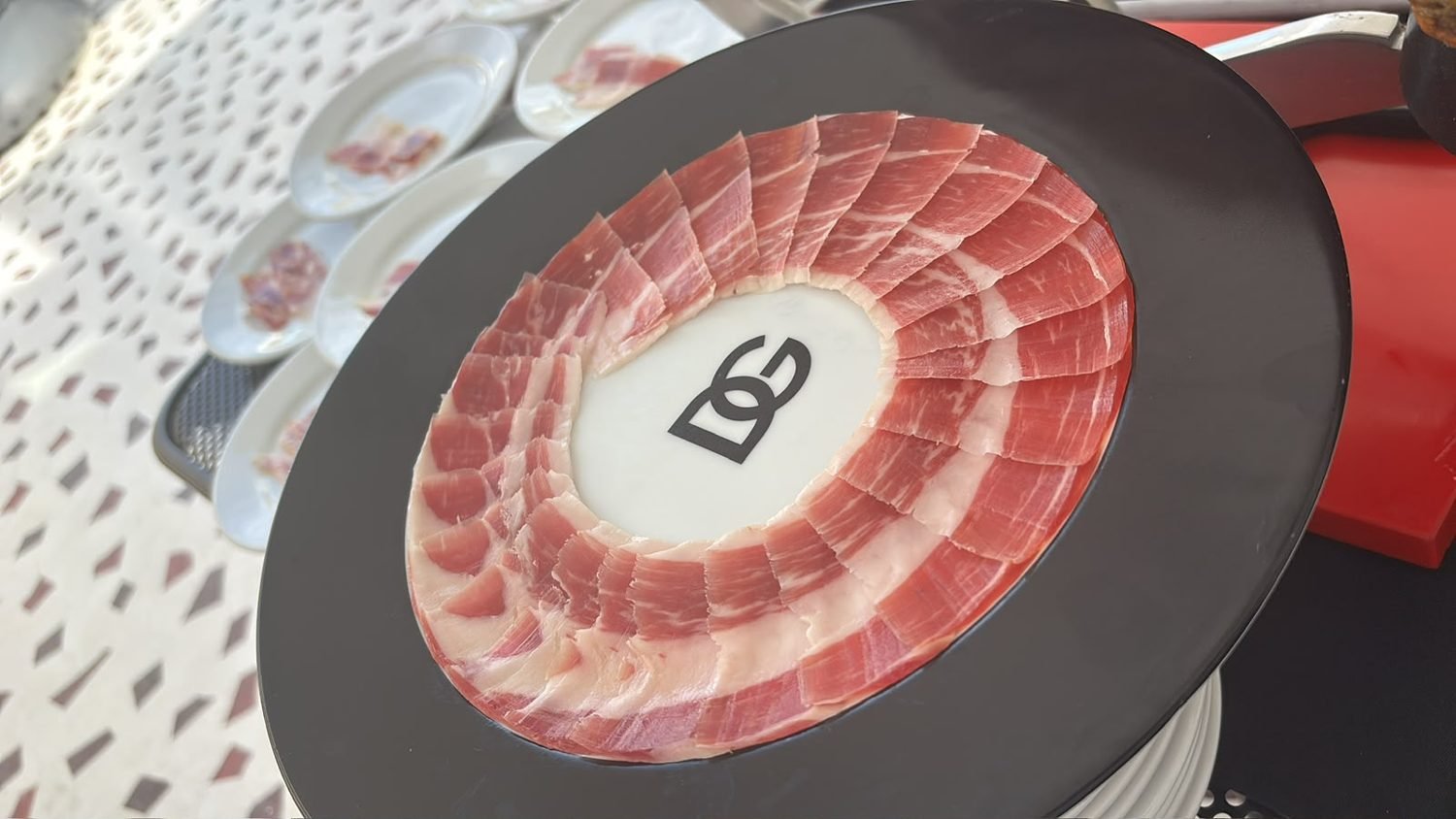 Plato negro de diseño con lonchas de jamón dispuestas en radios